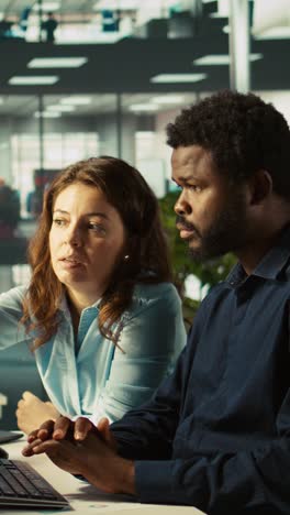 vertical video team leader showing employee mistakes to fix in business documents on pc