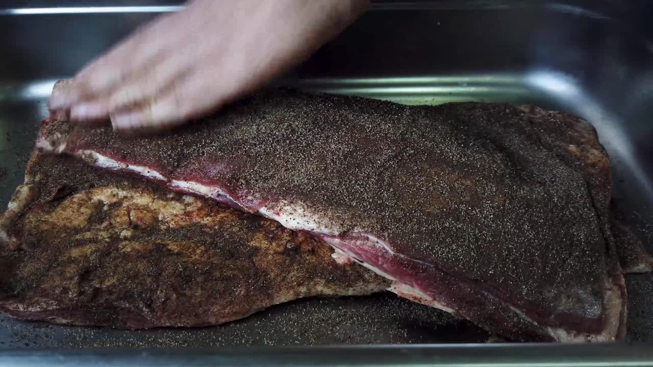 frotar la mezcla de condimentos secos en la carne cruda en preparación para cocinar
