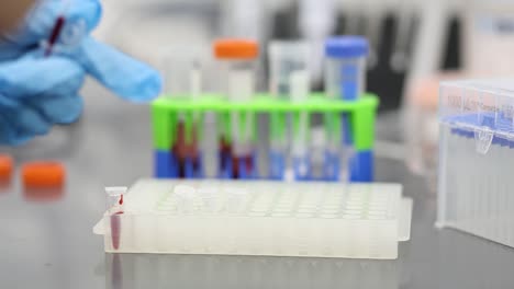 a red liquid being placed into a vial in a laboratory