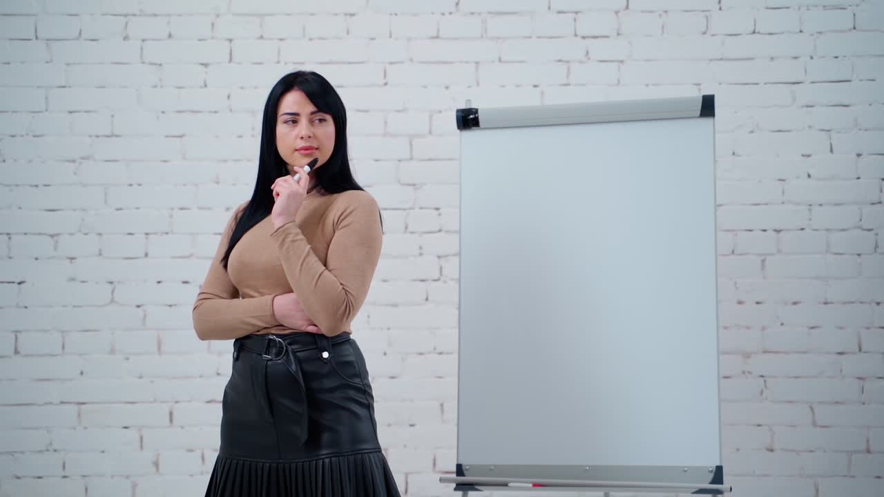 Portrait of a thoughtful businesswoman. Beautiful young female standing with a marker near the board and thinks about new ways in business.