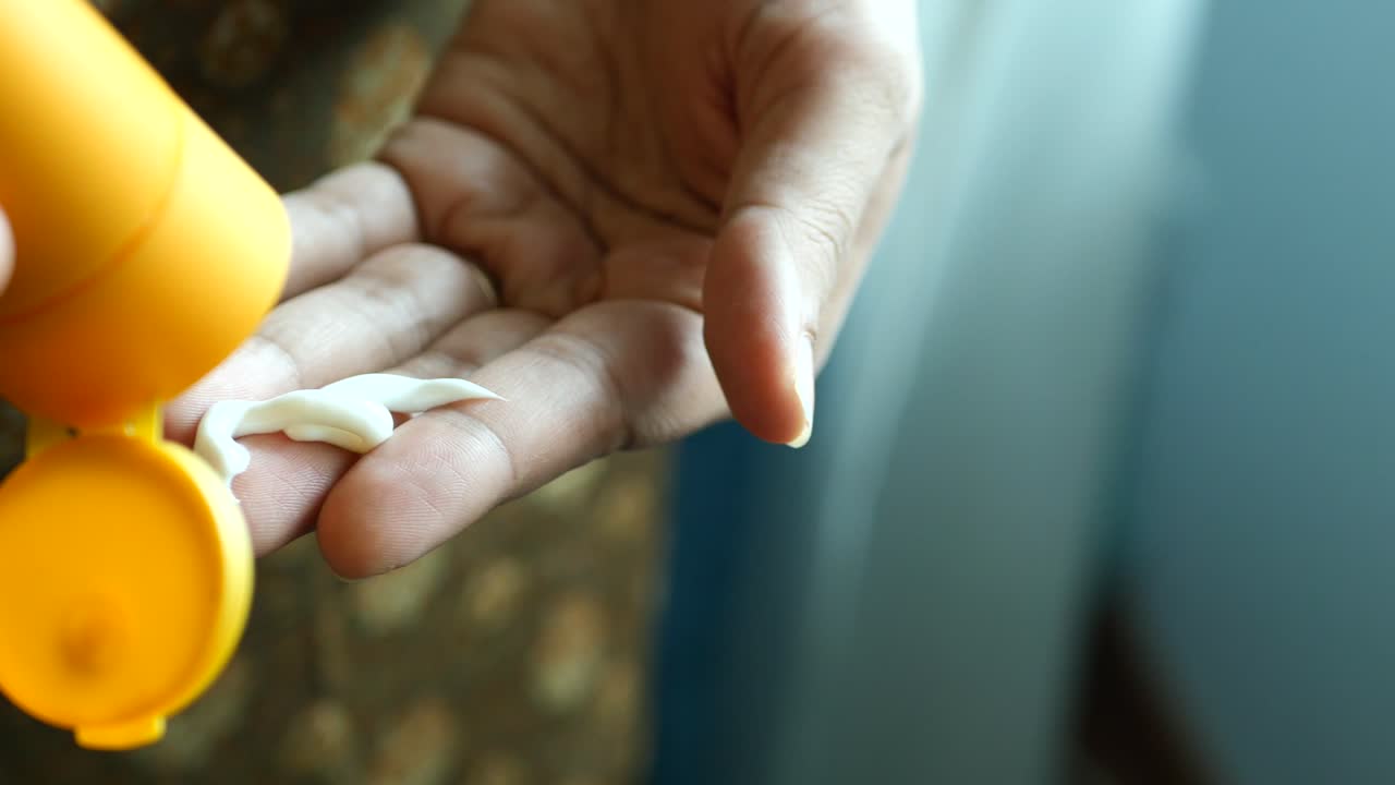 손 에 자외선 차단 로션 을 바르는 여자