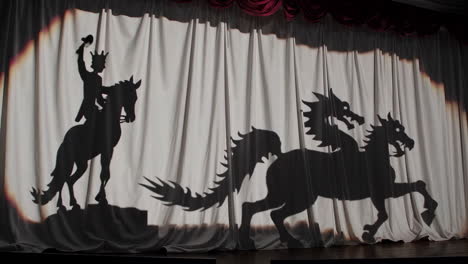 fantasy shadow play featuring a knight and a multi-headed dragon
