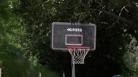 BasketBall-swishing-through-the-basketball-hoop-in-rural-courtyard