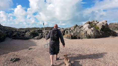 Man and Dog Walking on a Scenic Beach
