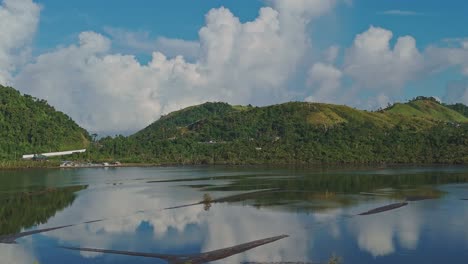 calm philippine fish ponds in surigao surrounded by hills covered in lush trees