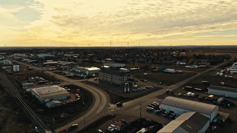 Aerial-view-of-the-city-of-Assiniboia-Canalta,-Saskatchewan,-Canada,-with-wind-turbines-in-the-background