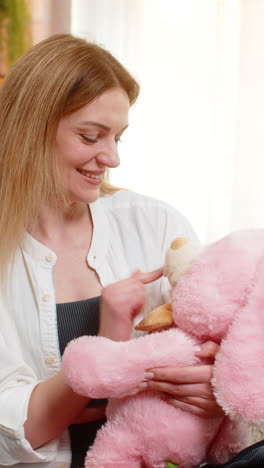 woman hugging plush toy at home smiling with comfort and calmness feeling safe emotionally grounded