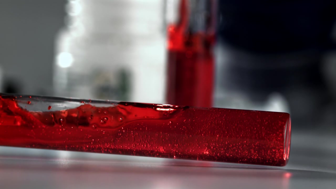 Liquido rosso che volteggia in una provetta in un laboratorio