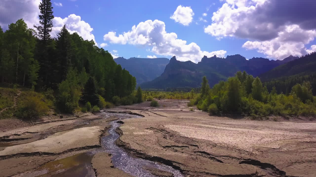 volando sobre un río colorado con montañas al fondo