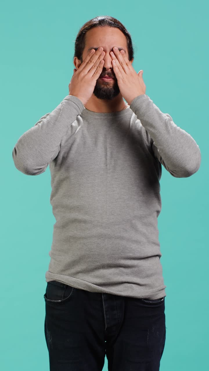 Vídeo vertical: hombre cubriéndose los ojos, los oídos y la boca, imitando a los tres monos sabios