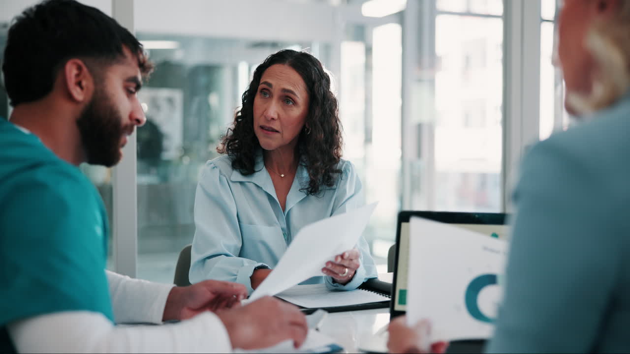 un grupo de personas en una reunión, discutiendo documentos