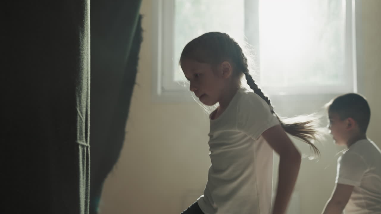 niña salta pateando bolsa de boxeo en el gimnasio junior. estudiante gira haciendo ejercicios con inventario de lucha en el club de artes marciales en cámara lenta. autodefensa