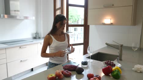 mujer preparando frutas y verduras frescas en una cocina