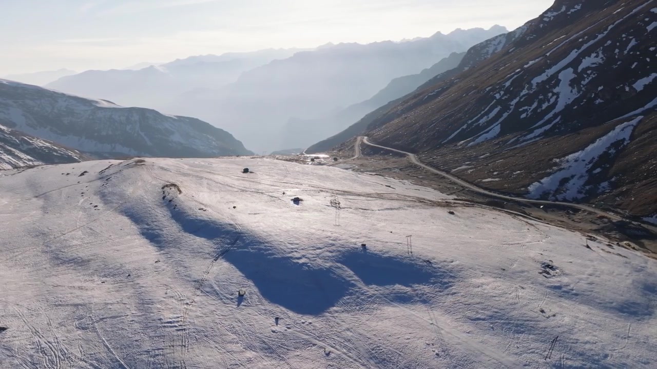 Rohtang Pass' snedækkede bjergvej snor sig gennem Pir Panjal-kæden i Himachal Pradesh, Indien. Luftdroneoptagelse afslører et øde vinterlandskab, der forbinder Kullu-dalen med Lahaul og Spiti