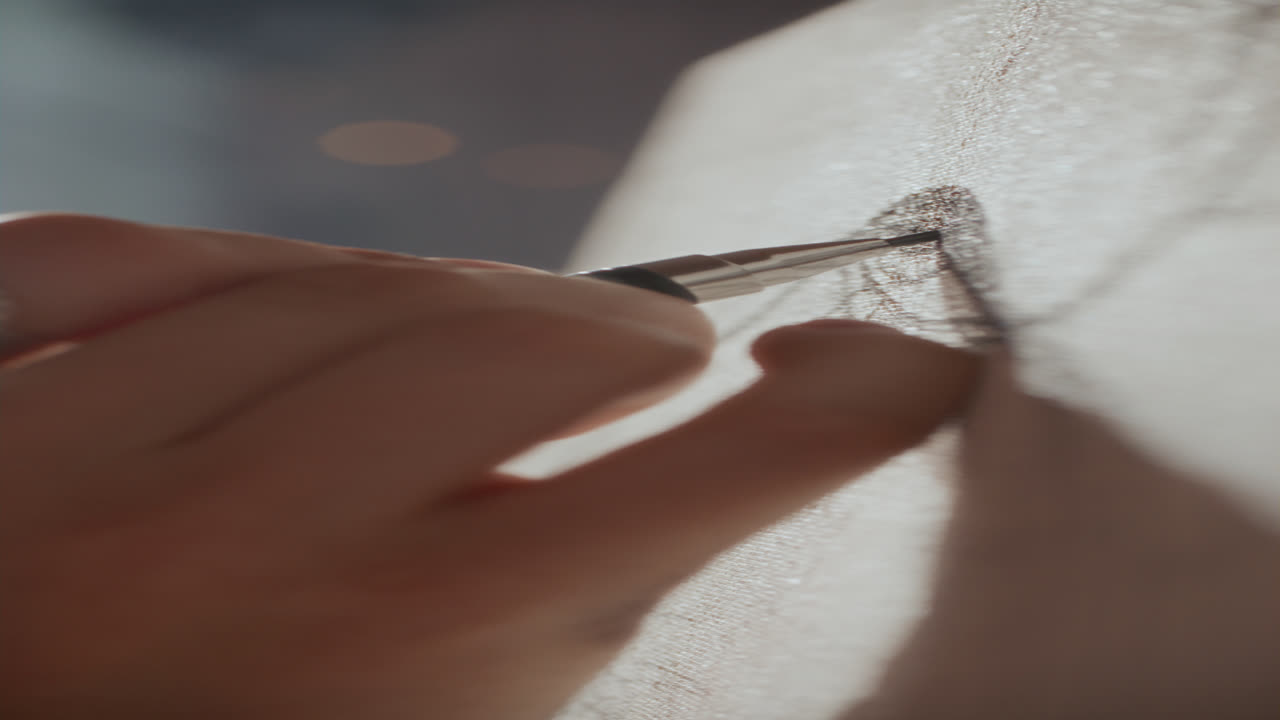 Close-up da mão de um artista desenhando detalhes de um olho com lápis na tela