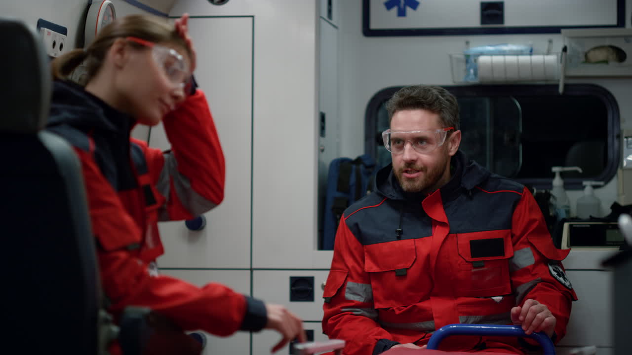 응급 의료 서비스 팀이 구급차에서 이야기하고 있습니다. 의사는 머리를 흔들고 있습니다.