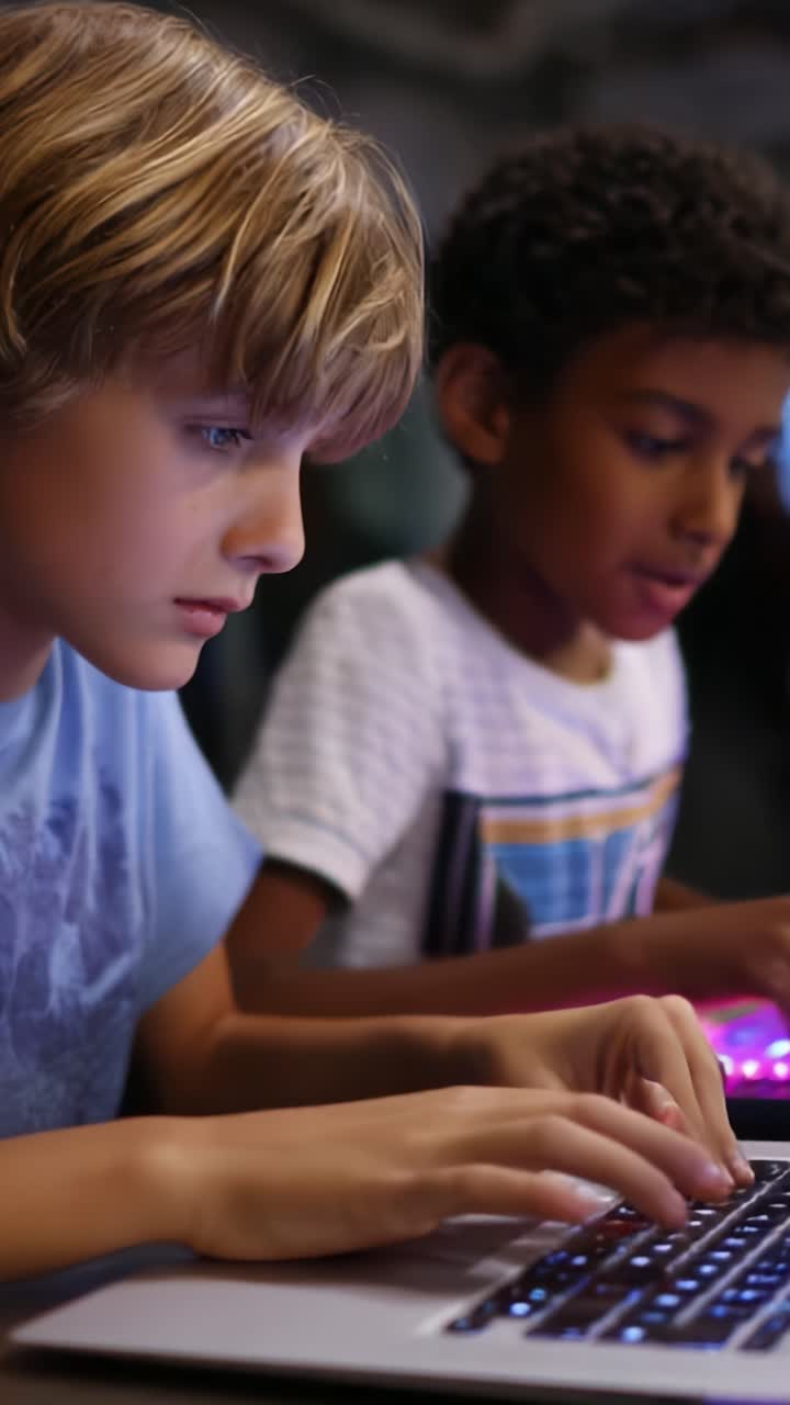 Two children engaged in a focused coding session on laptops, demonstrating teamwork and creativity through technology and learning while sitting side by side