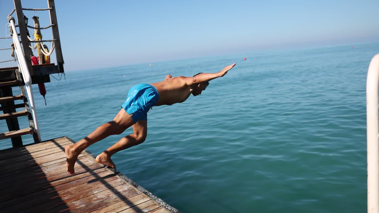 Man Diving into the Ocean from a Pier