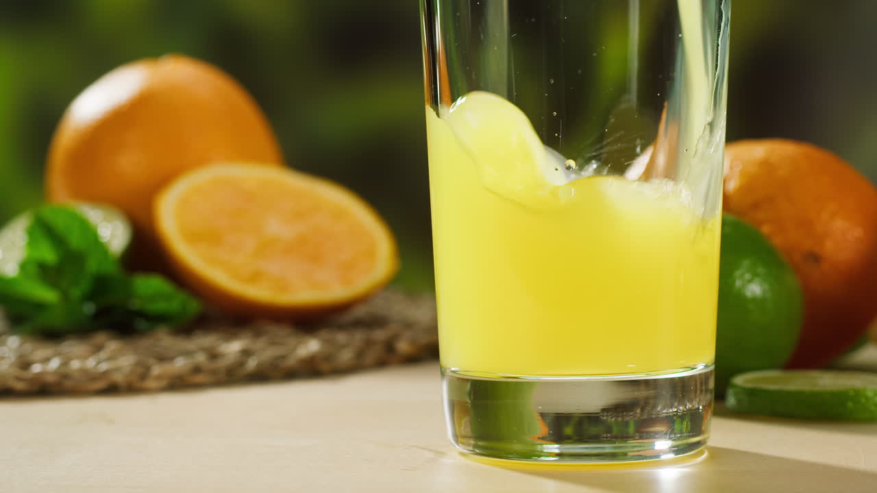 Succo d'arancia appena spremuto versato in un bicchiere con agrumi