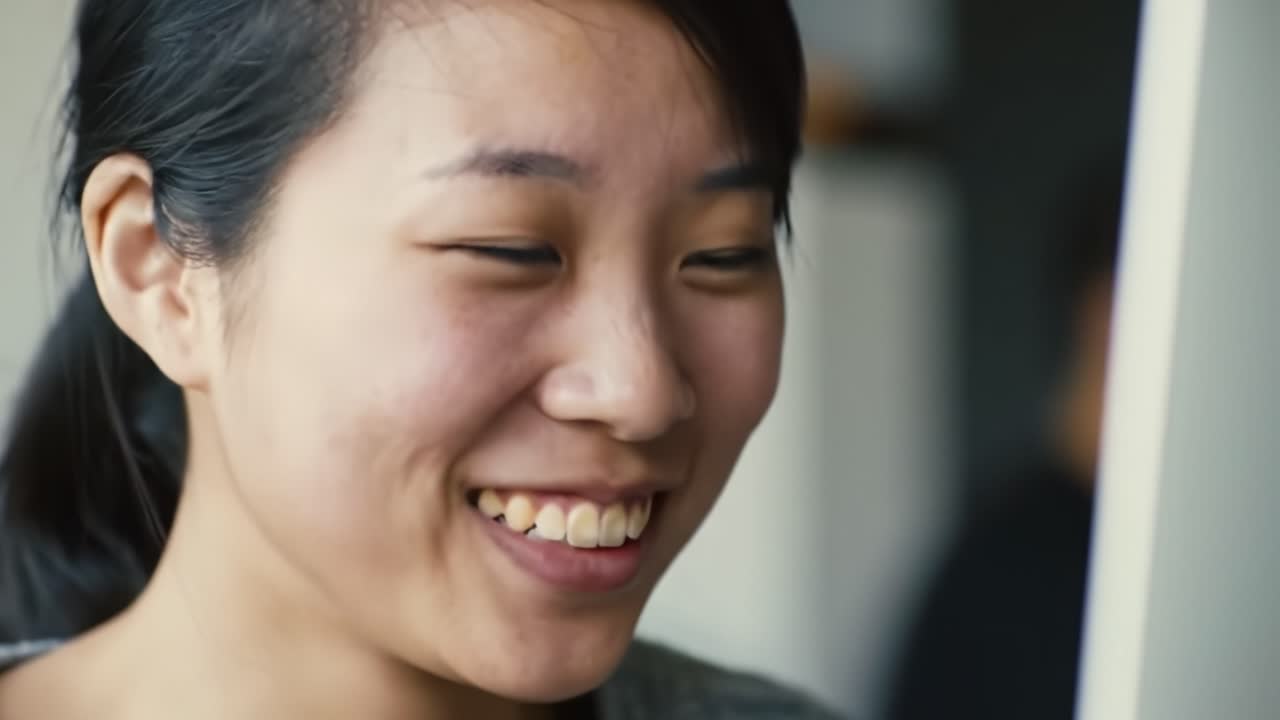 A Bright Smile and Genuine Laughter Captured in a Moment of Joy and Connection Between Friends in a Cozy Indoor Setting