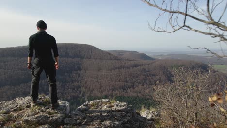 panoramic view behind a man walking towards a cliff in slow motion