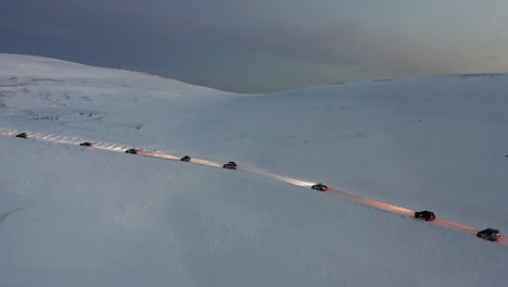 a convoy of cars going towards the most northern part of europe, the nordkapp, during a cold and dark winter day