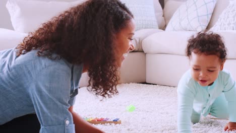 black toddler boy crawling around his kneeling young mother