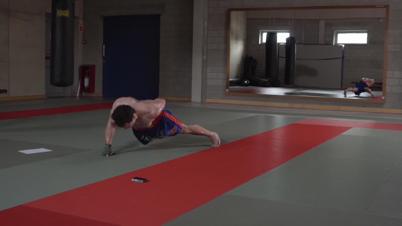 тренировка с российским и армянским кикбоксером, выполняющим отжимания на одной руке в тренажерном зале