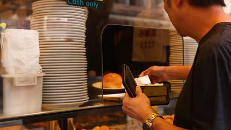 man purchasing dessert at a bakery counter