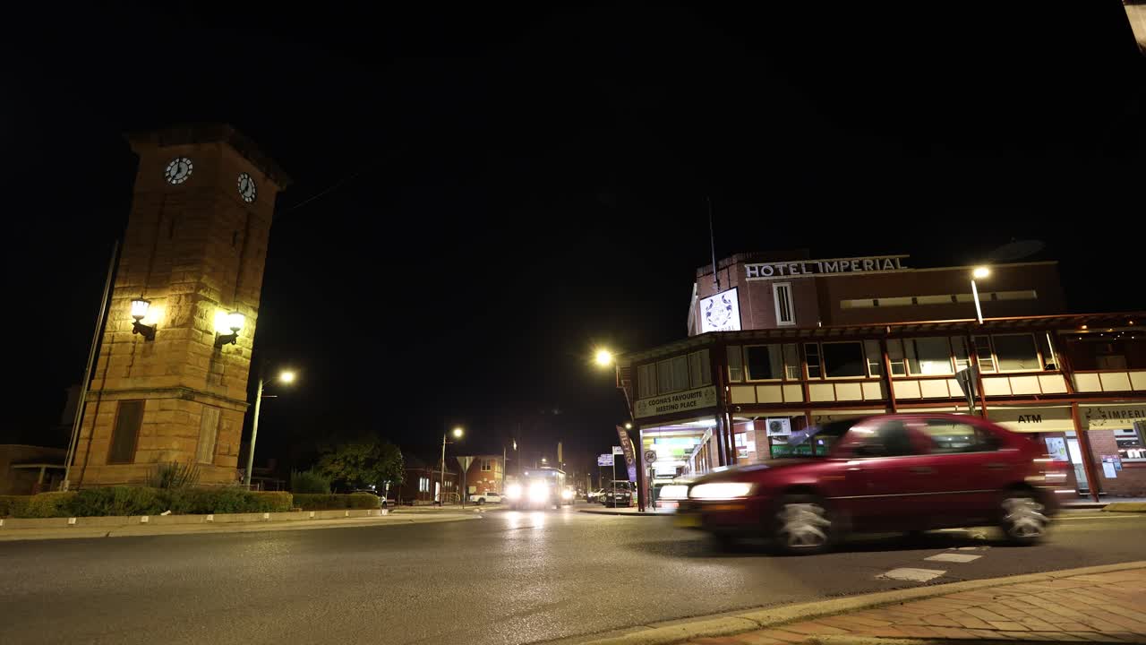 транспортные средства проходят мимо старого здания ночью