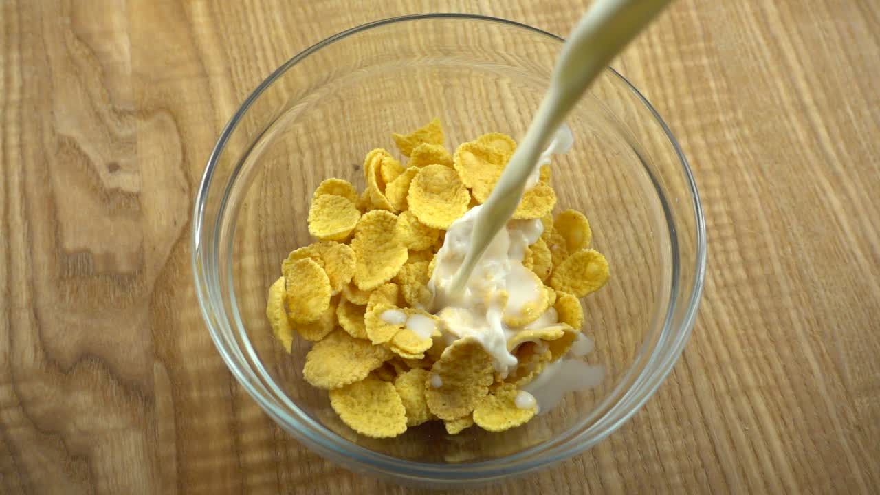 I corn flakes vengono versati con il latte. Rallentatore.