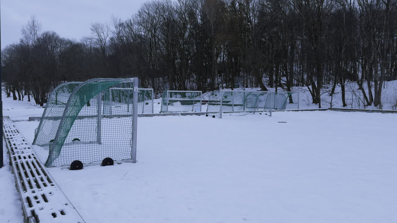 Široký záběr fotbalových branek stojících ve sněhu, zima dorazila do Norska a sezóna skončila.