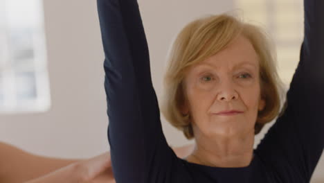 yoga class of healthy mature women exercise instructor teaching warrior pose training posture enjoying morning physical fitness workout in studio