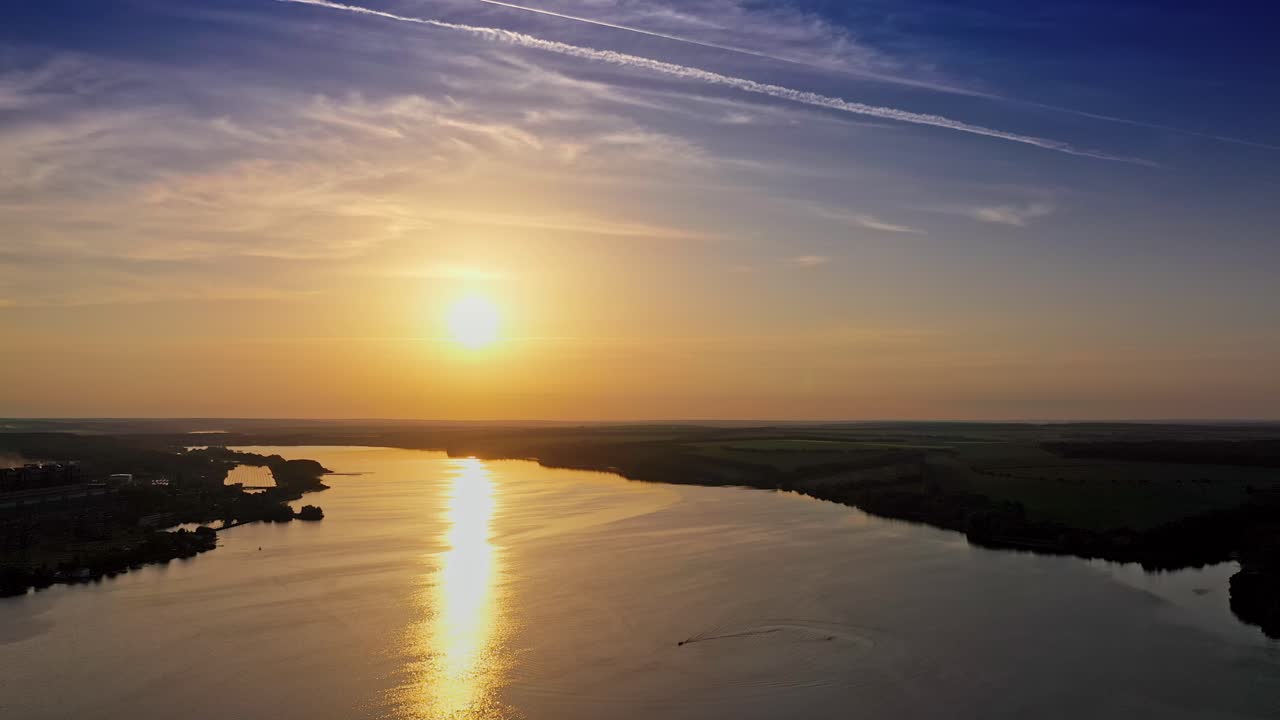 Golden path over water surface at sunset. Beautiful view on the natural landscape with evening sun that reflects in water. Aerial view.