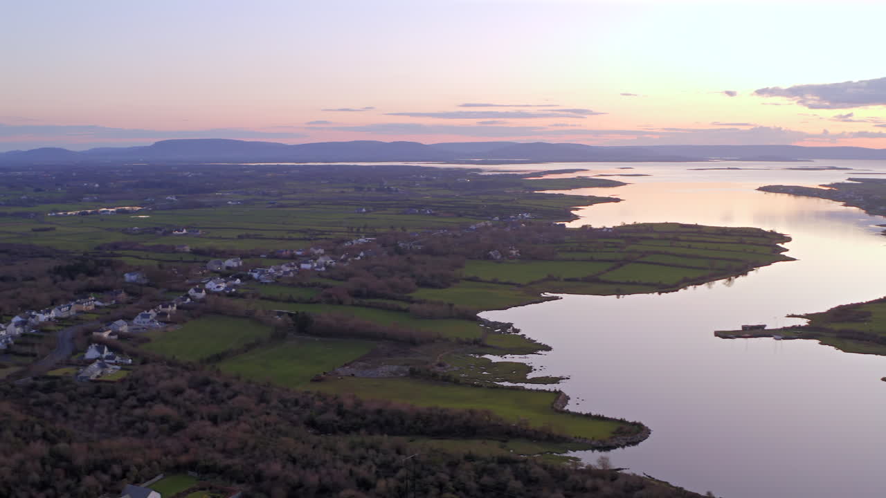 Aerial overview pan of landscape of Clarinbridge fields and homes under subtle sunset light