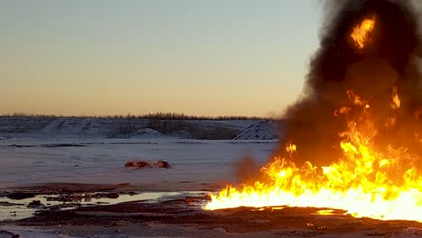 toma panorámica derecha de un enorme derrame de petróleo ardiendo en la nieve