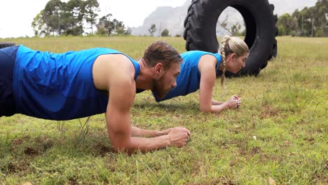 Hombre-Y-Mujer-En-Forma-Haciendo-Ejercicio-Durante-La-Carrera-De-Obstáculos