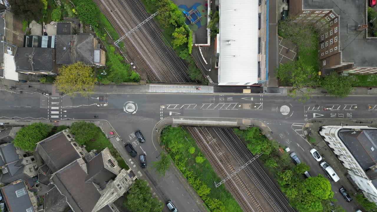Drone flying over a London suburban neighborhood with cars driving on the road, filmed in 4K 60FPS. Perfect for calm, urban lifestyle, and travel projects