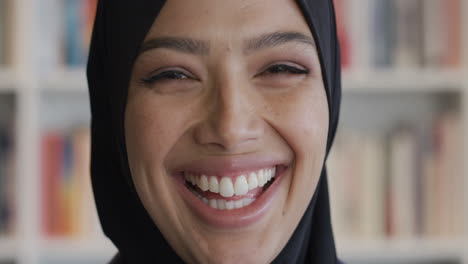 happy student woman laughing in front of bookshelf