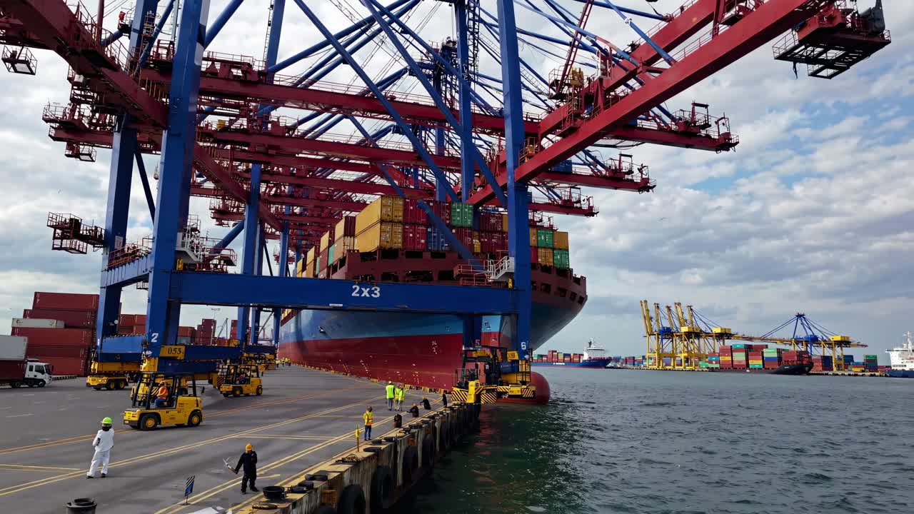 Wide-angle shot of a bustling port with cranes unloading a cargo ship