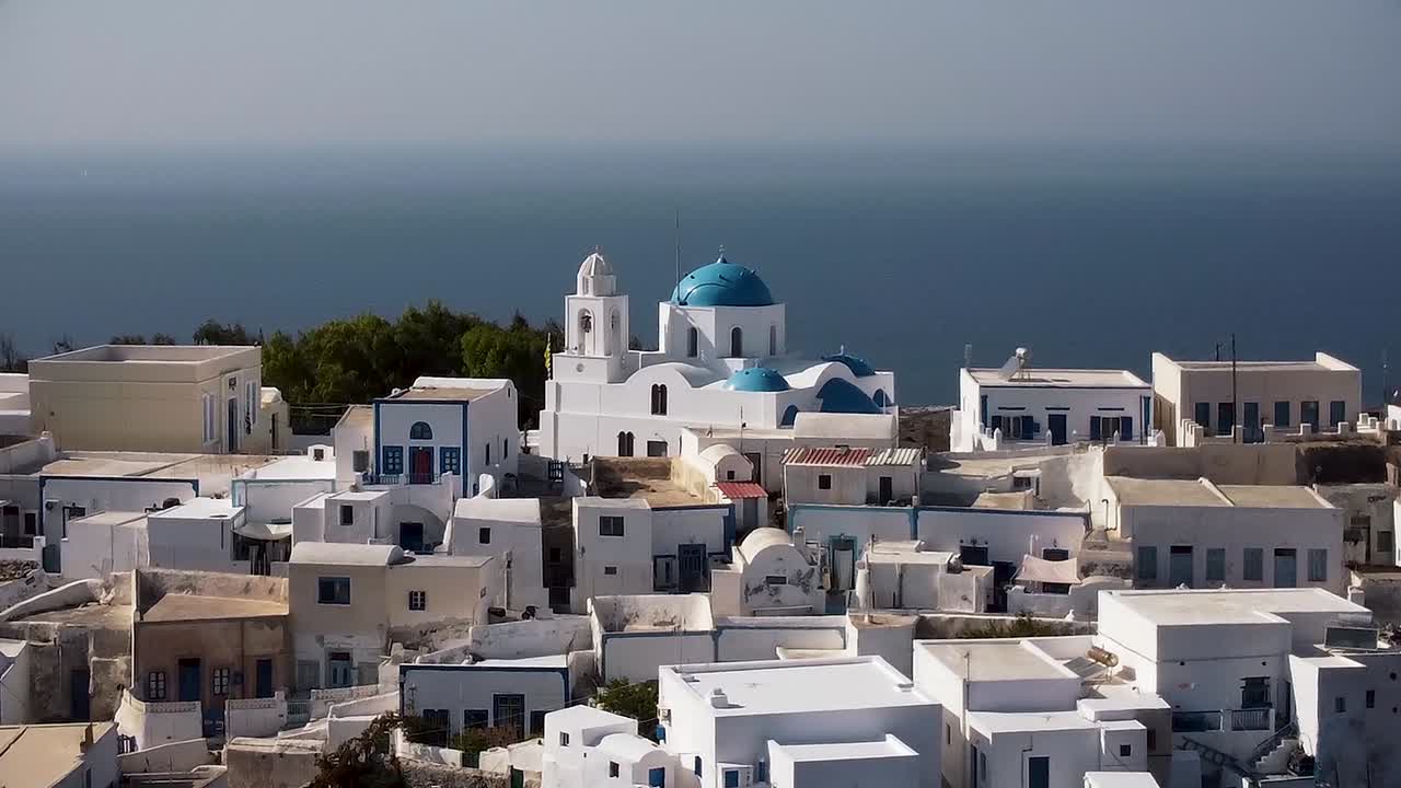 dolly aérea de cúpula azul tiro chrch en santorini thirasia