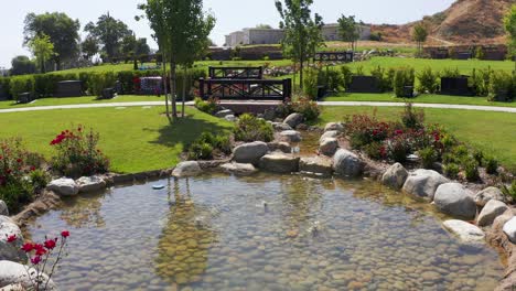 low aerial shot flying over a small stream running through a decorated private estates burial lawn at a california mortuary