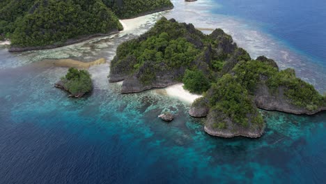 Mesmerizing-view-around-tropical-island-with-high-rock-formations,-coral-reef,-and-turqoise-water-in-the-Last-Paradise-Of-Raja-Ampat-Indonesia