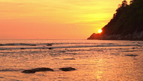 Amazing-view-of-sun-hiding-behind-sea-cliff-at-sunset