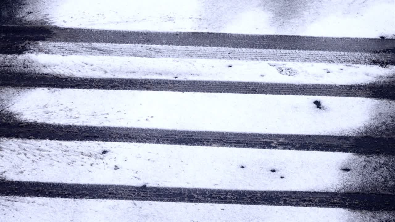 Pattern of the cars on a snow capped street, slow motion snowfall on a cold winter day, static shot, copy space
