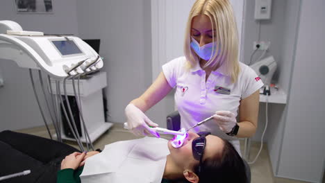 woman dentist teeth health care. ultraviolet stomatology treatment.