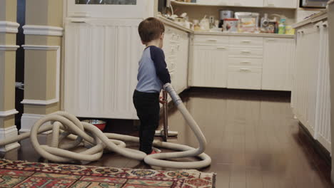 Asian-two-year-old-toddler-trying-to-vacuum-in-a-room