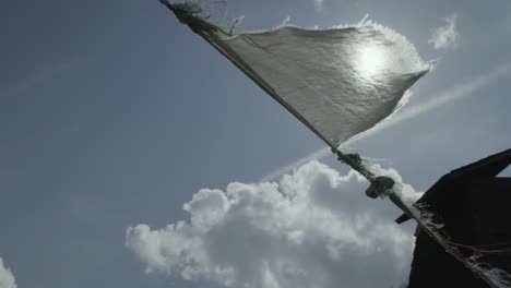 weiße flagge, die von russischen soldaten in der ukraine gegen sonnenschein an einem seil in der nähe eines gebäudes gehisst wurde