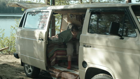 female camper petting dog in travel trailer