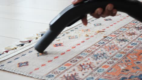 a closeup of a rug being vacuumed